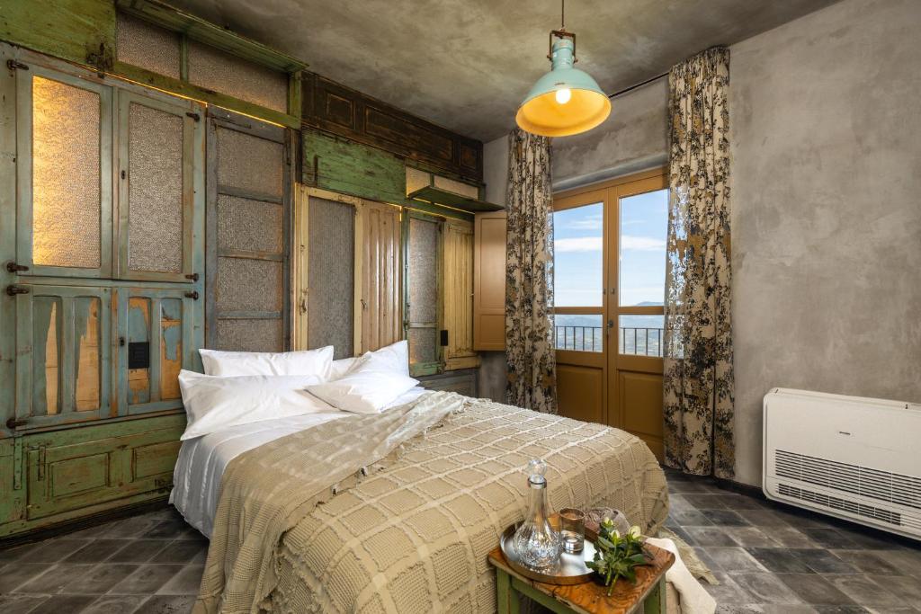 a bedroom with a bed and a large window at Via Roma Charming Rooms in Baunei