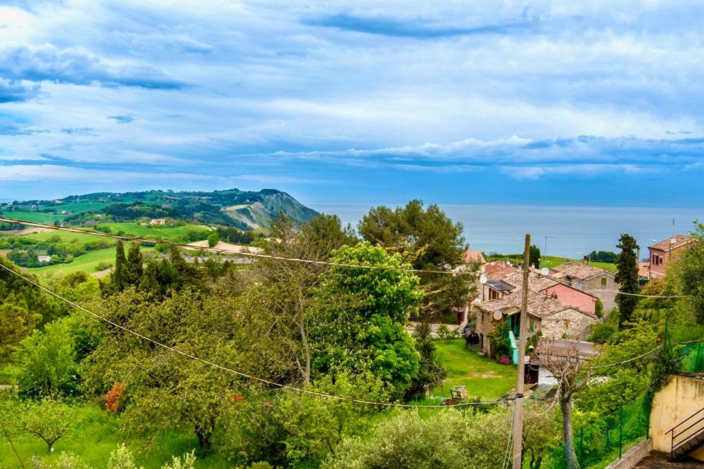 uma aldeia nas colinas com casas e árvores em A27 - Poggio, quadrilocale con vista sul mare di Portonovo em Ancona