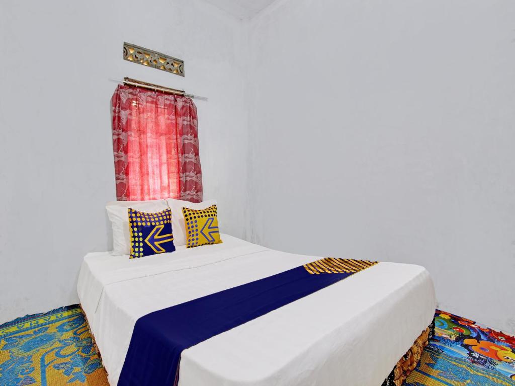 a bedroom with a bed with a window at SPOT ON 92535 Guest House Pak Darso in Sragen