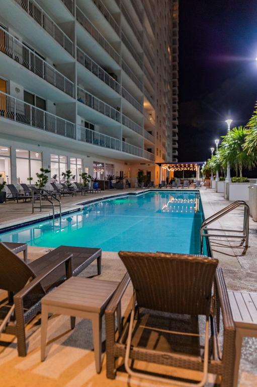 a swimming pool at night with chairs and a hotel at Studios in Brickell with Pool, Gym, free parking and Game Room in Miami