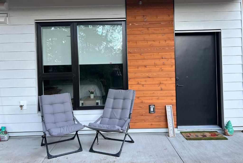 duas cadeiras sentadas num alpendre em frente a uma casa em Victoria private studio suite em Victoria