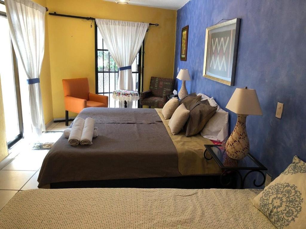 a bedroom with two beds and a blue wall at Suite Antequera en mexico in Oaxaca City