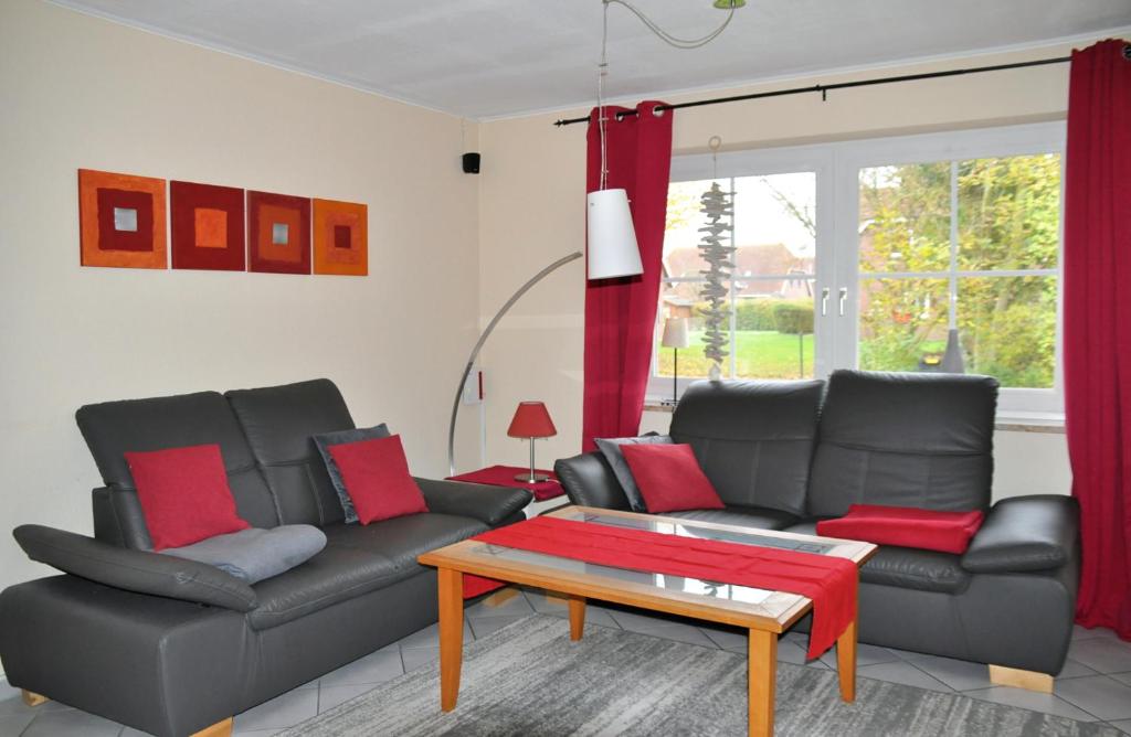 Sala de estar con 2 sofás de cuero y mesa de centro en Petersdorf Ferienwohnung Kleine Auszeit, en Westfehmarn