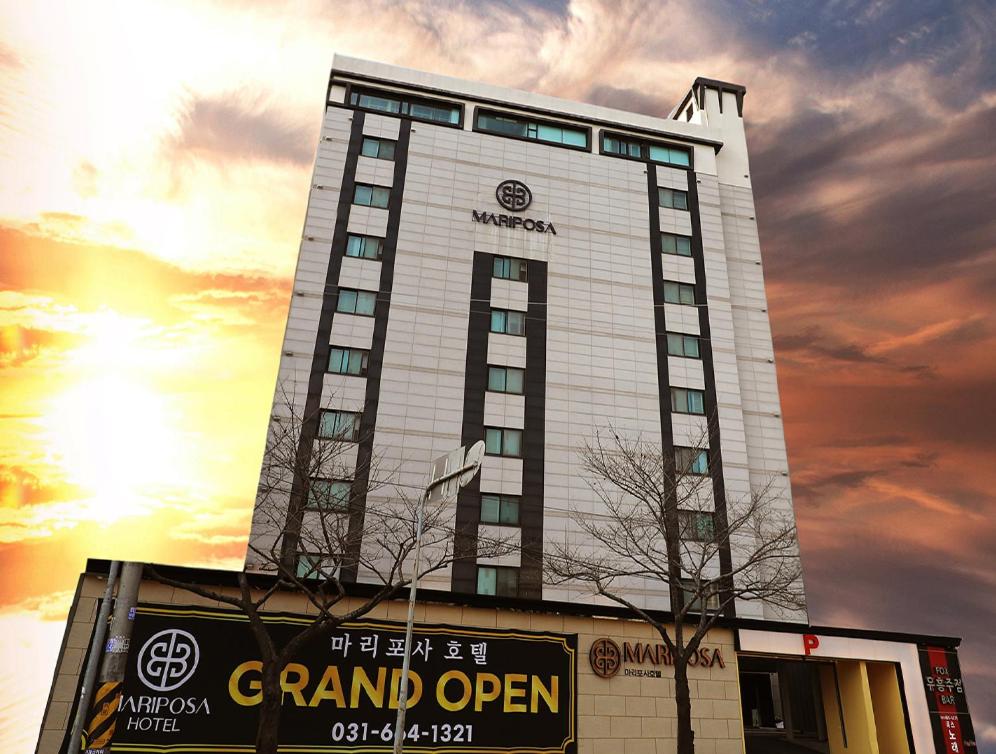 a tall building with a sign in front of it at Mariposa Hotel Songtan in Pyeongtaek