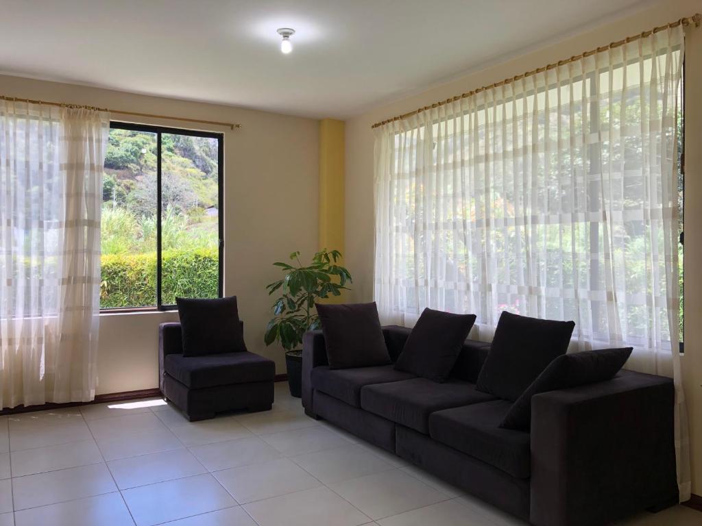 a living room with a couch and two chairs and a window at Family house/casa de Familia 3 bedroom 3 bath in Baños