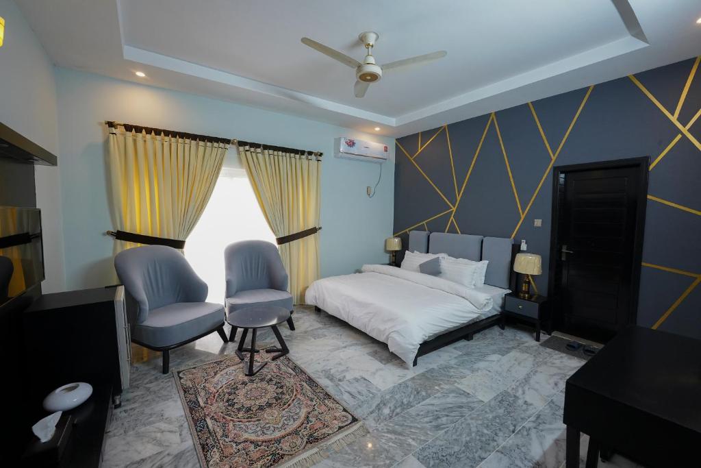 sypialnia z łóżkiem i 2 krzesłami w obiekcie SK Residence w mieście Islamabad