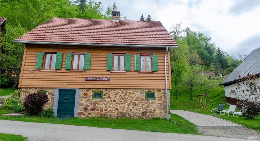 une petite maison avec volets verts sur son côté dans l'établissement Kuća za odmor ''Julka'', à Plešce