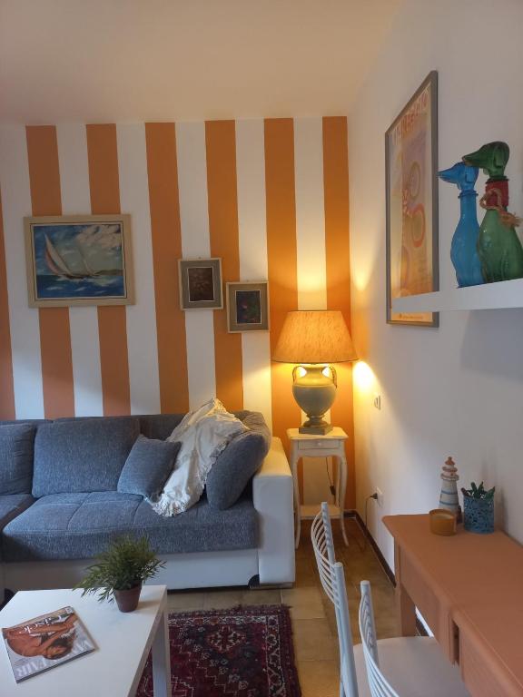 a living room with a blue couch and striped walls at Verahouse in Viareggio