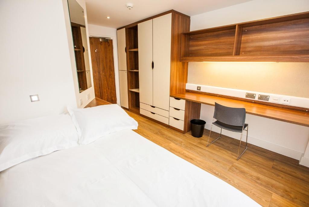 a bedroom with a bed and a desk and a chair at Willow Court in Stirling