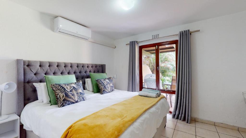 a bedroom with a large white bed and a window at San Lameer Villa 2502 by Top Destinations Rentals in Southbroom
