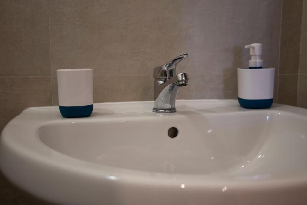 a bathroom sink with two cups on top of it at FRONTE MARE in Palermo