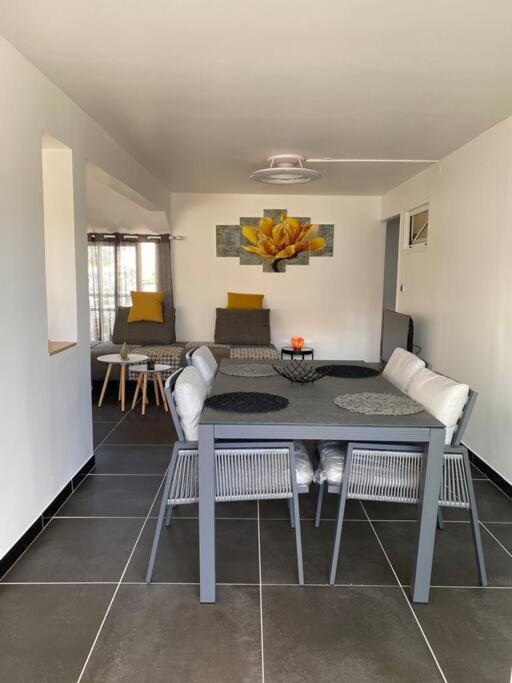 a living room with a table and chairs and a couch at brin de mer in Saint-Pierre