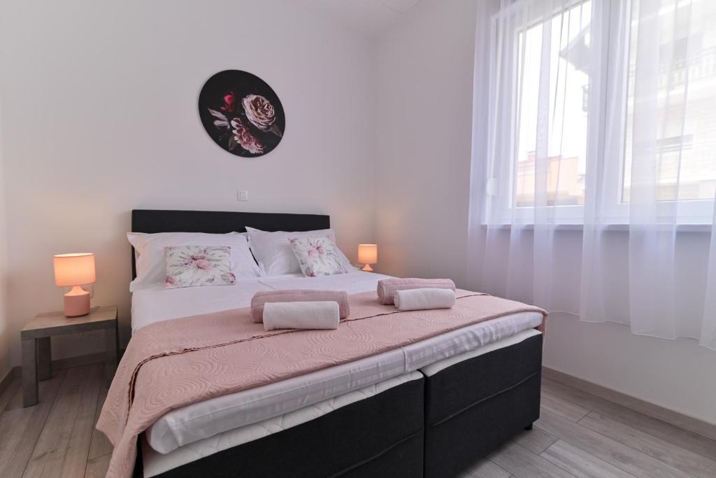 - une chambre avec un grand lit et 2 lampes dans l'établissement Apartmani Castrum, à Kaštela