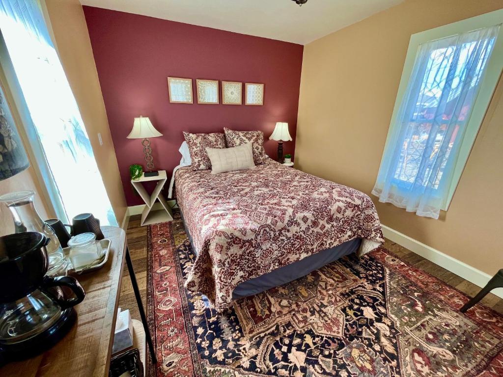 una camera con letto e parete rossa di Violet Cottage at Zenzen Gardens a Paonia