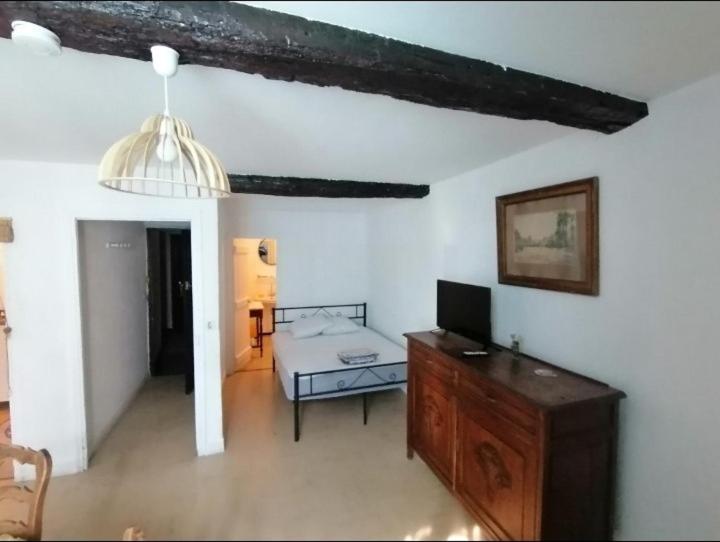 - un salon avec un lit et un bureau avec une télévision dans l'établissement Chez Mamy Dée 3, à Castellane