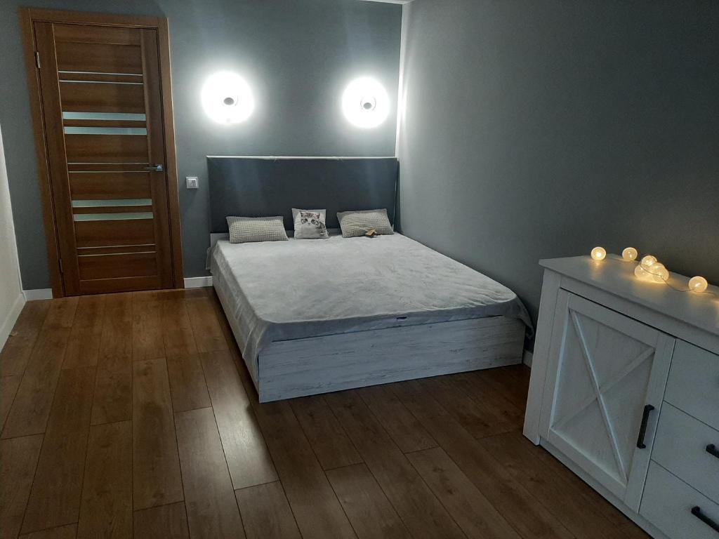a bedroom with a bed and two lights on the wall at Апартаменти з власним двориком in Khotov