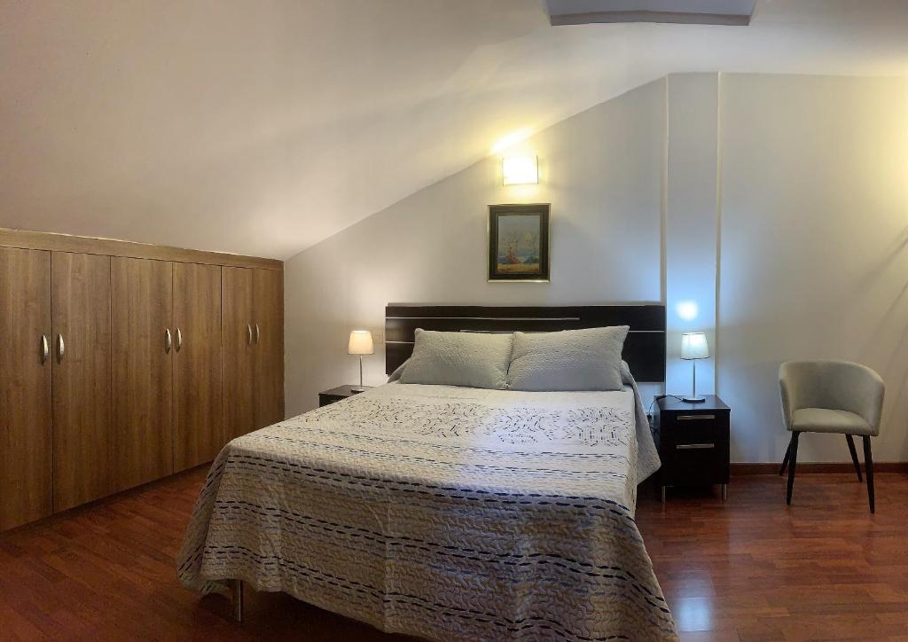 Valleseco的住宿－Viviendas Vacacionales en el centro de Valleseco，一间卧室配有一张大床和一把椅子