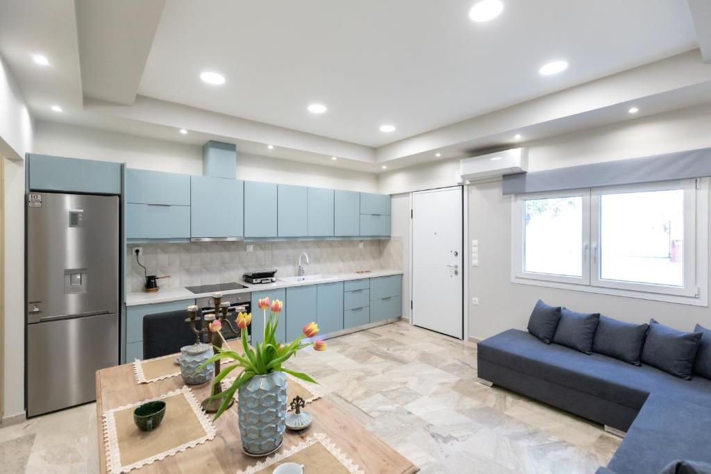 a kitchen with blue cabinets and a blue couch at Garden Apartment in Amarynthos I in Amarynthos