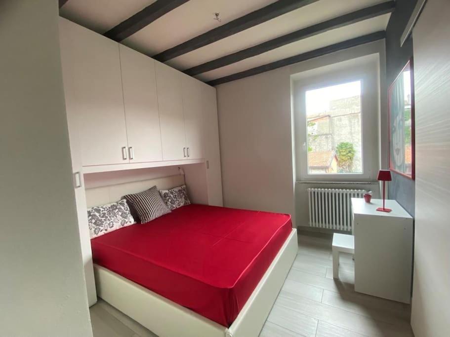 ein Schlafzimmer mit einem roten Bett und einem Fenster in der Unterkunft Marilyn Apartment in Como