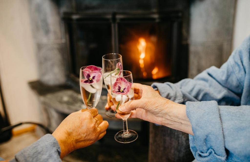 two people holding champagne glasses in front of a fireplace at Ollinmäki Vineyard in Anttola