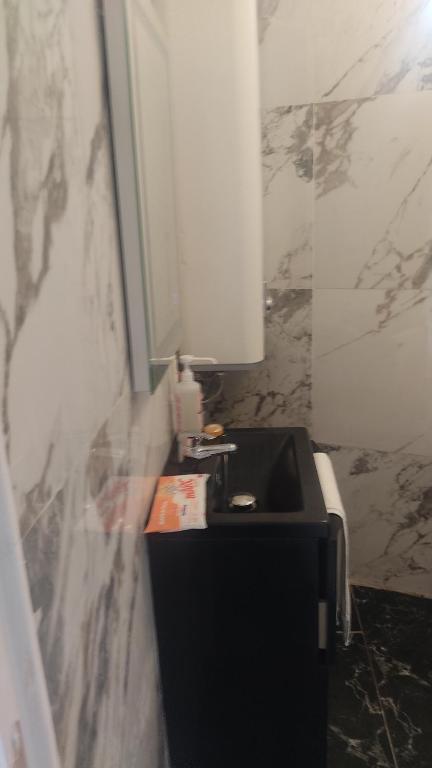 ein Badezimmer mit einem schwarzen Waschbecken und einer Marmorwand in der Unterkunft Cannes Centre in Cannes