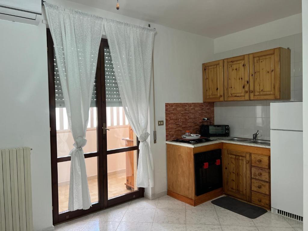 a kitchen with a sliding glass door with a window at Calamaterdomini a 2 passi dal mare in Brindisi