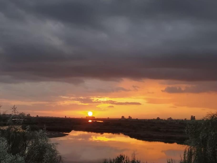 a sunset over a river with the sun setting at La casita de Poniente. Enjoy it! in Huelva