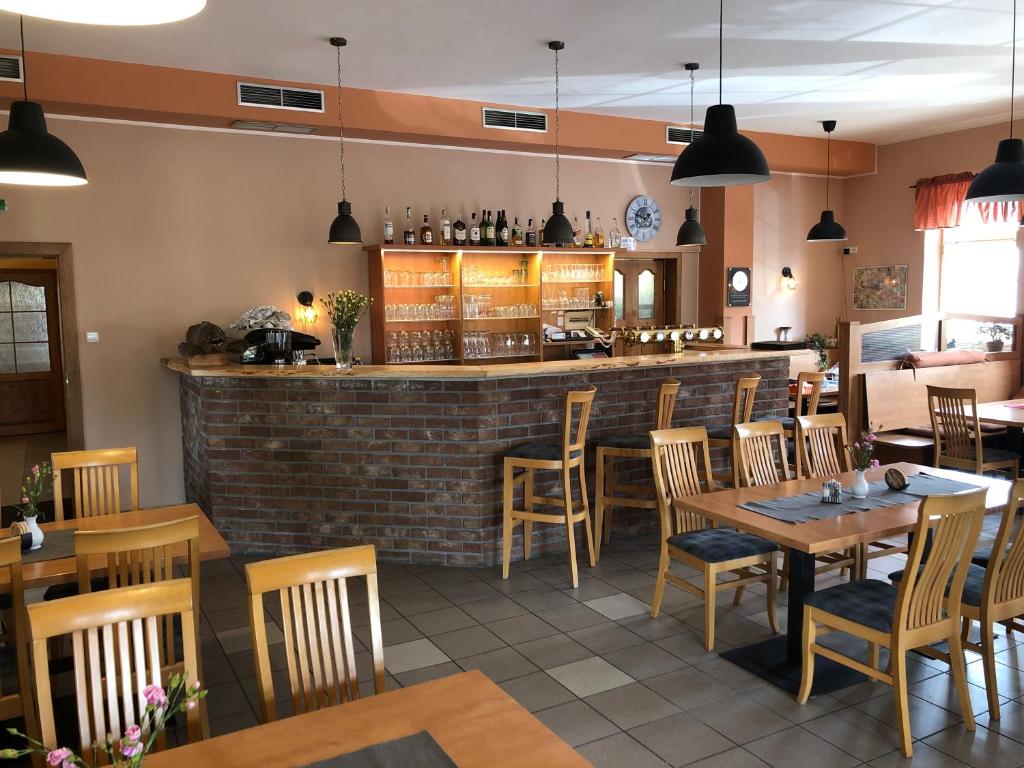 ein Restaurant mit Tischen und Stühlen und eine Bar in der Unterkunft Restaurace - penzion Bavorský dvůr in Sezemice