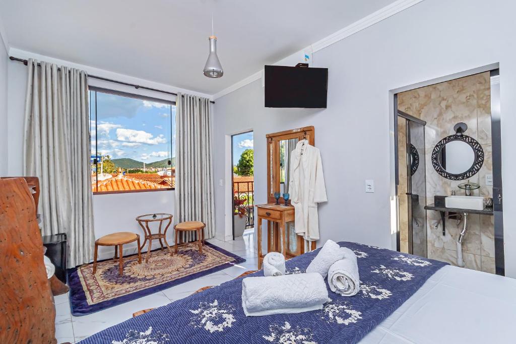 Cet appartement comprend une chambre avec un lit et une salle de bains avec un balcon. dans l'établissement SPA&Hospedagem Giovannini, à Pirenópolis