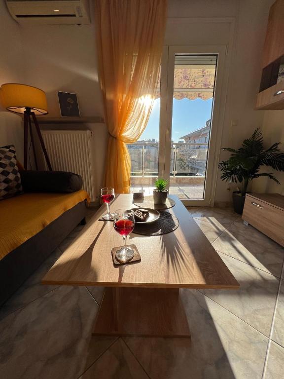 a living room with a table with two glasses of wine at Casa Armonia in Nea Kallikrateia