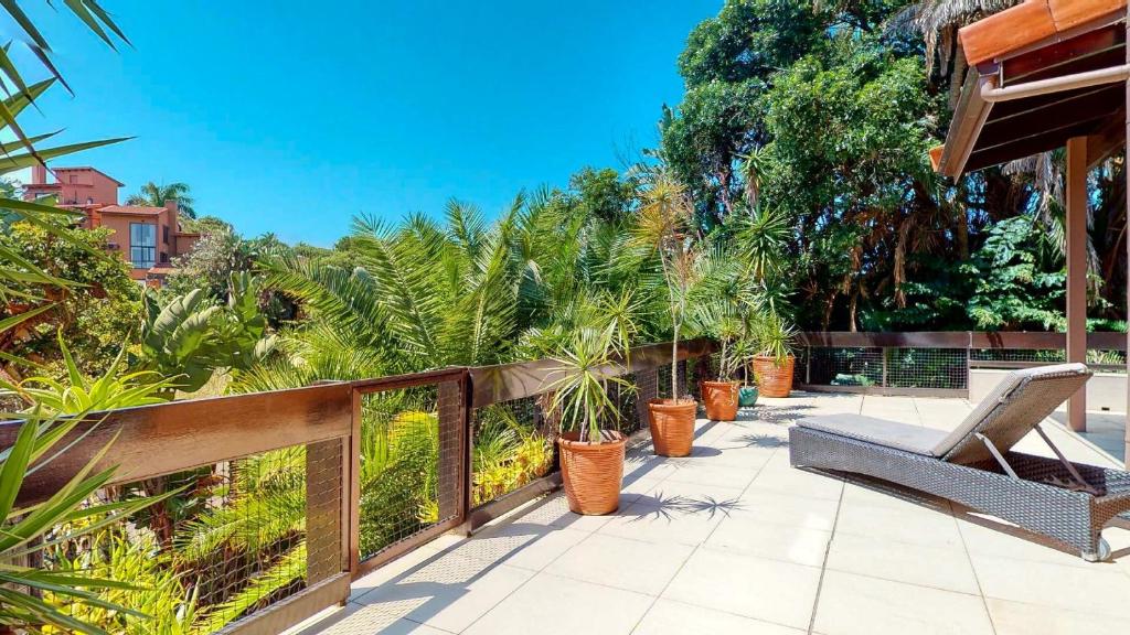 eine Terrasse mit einer Bank und einem Zaun mit Pflanzen in der Unterkunft San Lameer Villa 3112 Top Destinations Rentals in Southbroom