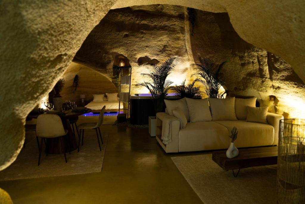 a living room with a couch in a cave at La falaise perdue : Suite troglodyte grandiose in Doué-la-Fontaine