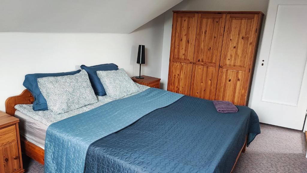 シオーフォクにあるSiófoki nyaralóházのベッドルーム1室(青いベッド1台、木製キャビネット付)