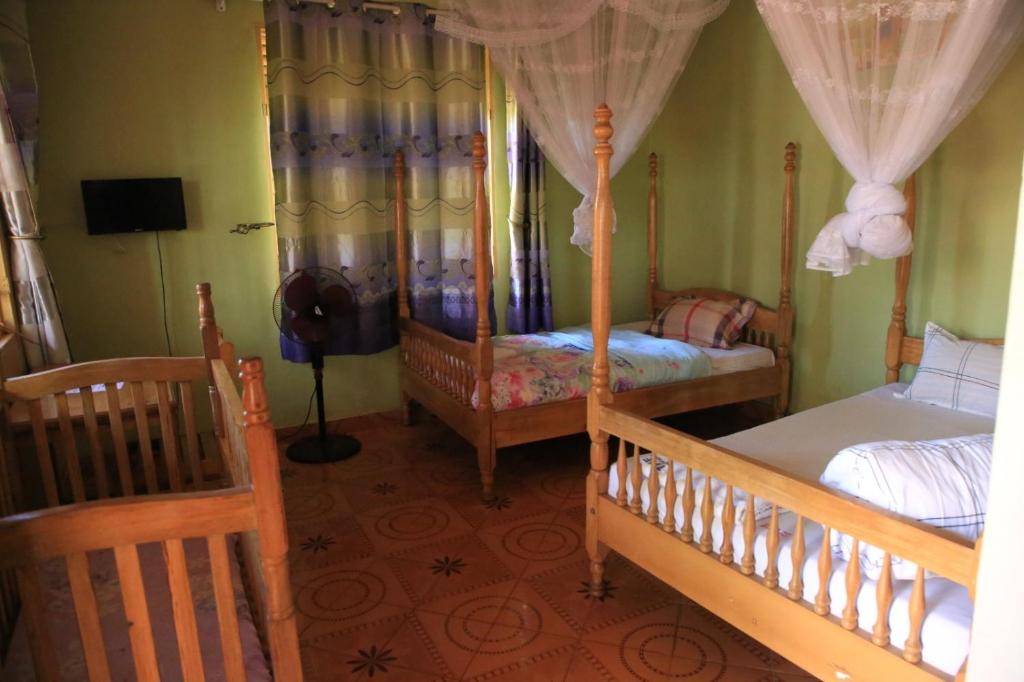 a bedroom with two bunk beds and a tv at The Roots classic hotel in Njeru