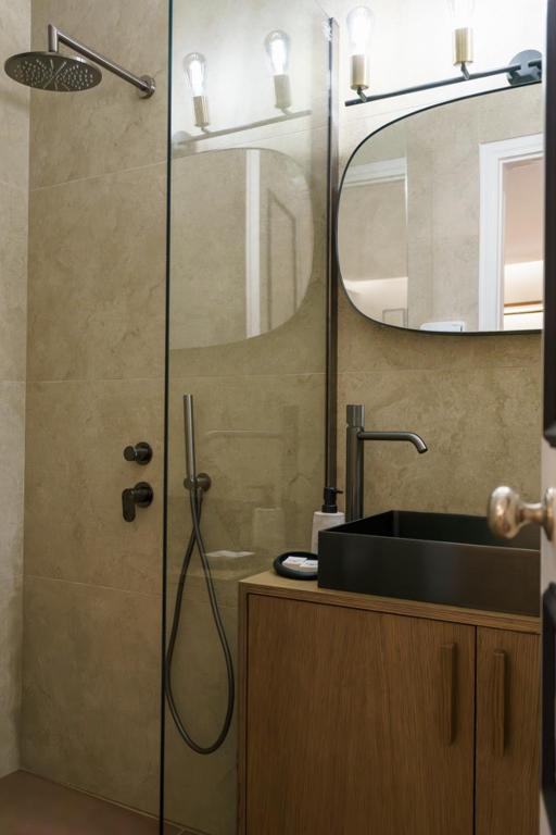 y baño con ducha, lavabo y espejo. en Alkionides Hydra, en Hydra