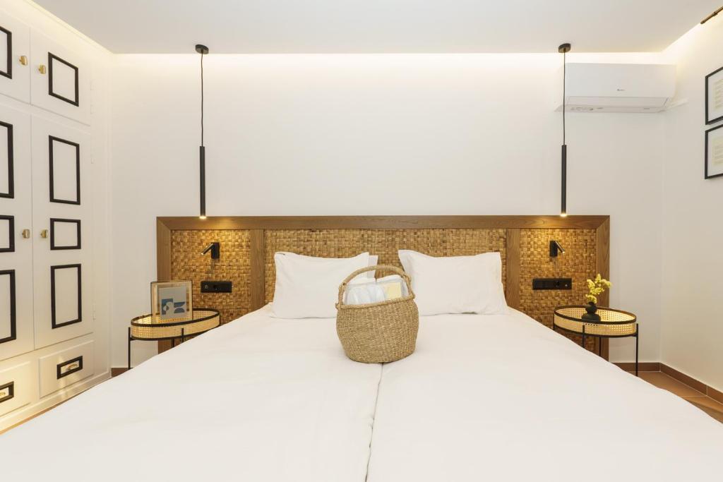 1 dormitorio con 1 cama blanca grande y 2 mesas en Alkionides Hydra, en Hydra