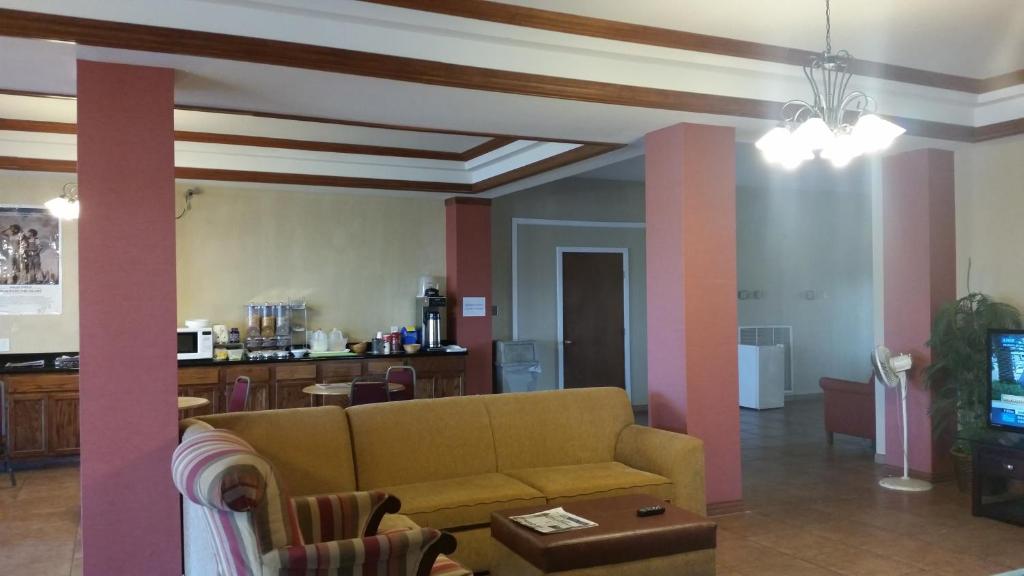 a living room with a couch and a tv at Executive Inn and Suites Waxahachie in Waxahachie