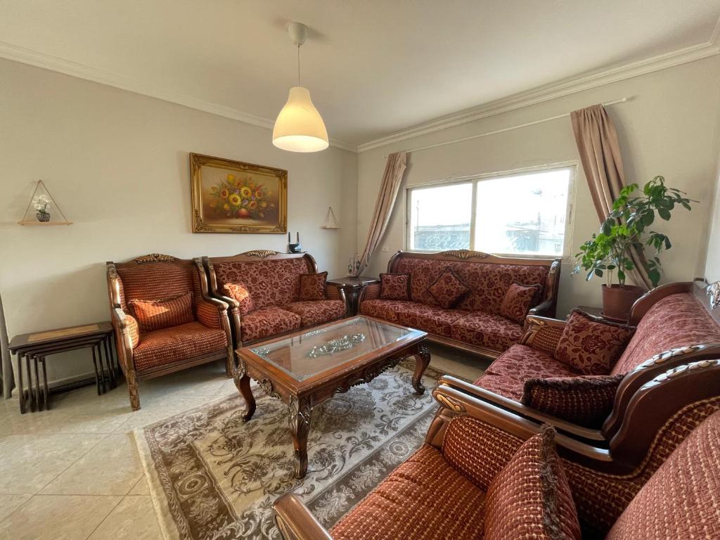a living room with couches and a coffee table at Mahfouz Suite - Ajloun's downtown in Ajloun