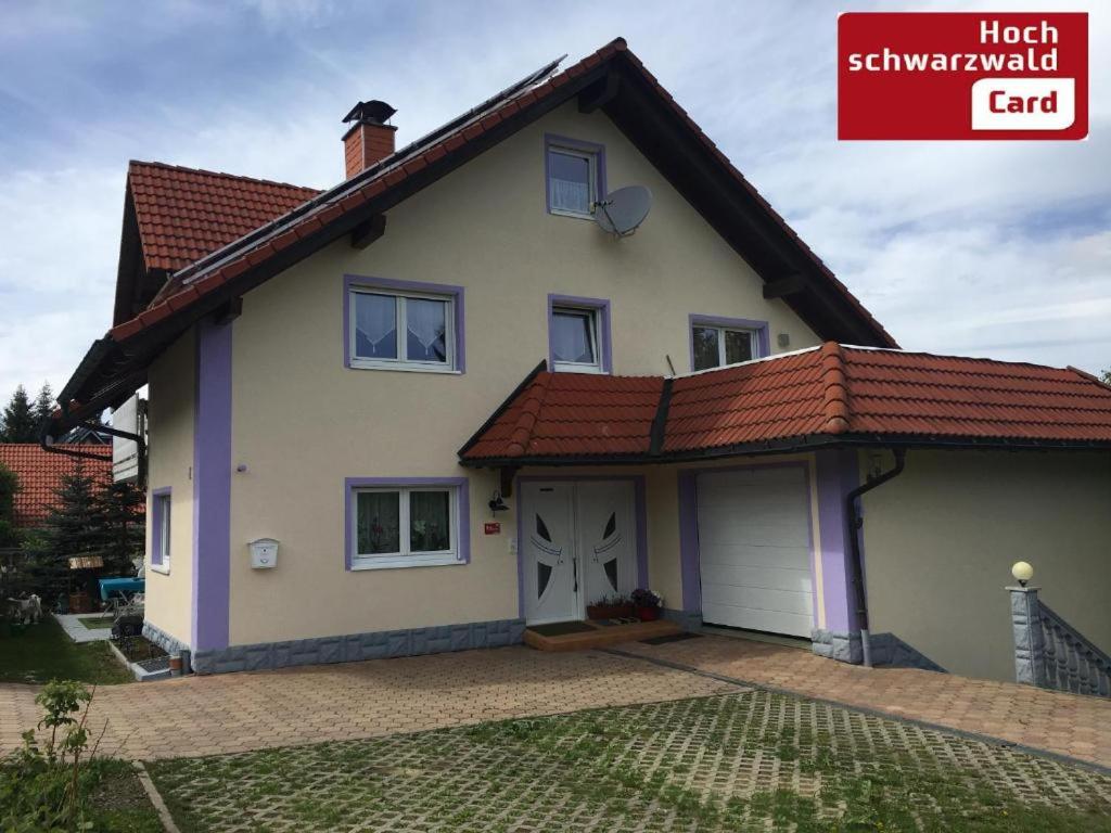 een wit huis met een rood dak bij Haus Zeichner 2 Zimmer Ferienwohnung in Feldberg