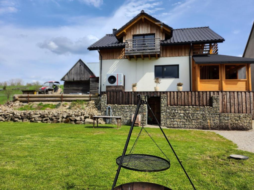 a house with a tennis racket in the grass at Apartament u Ewki in Rdzawka