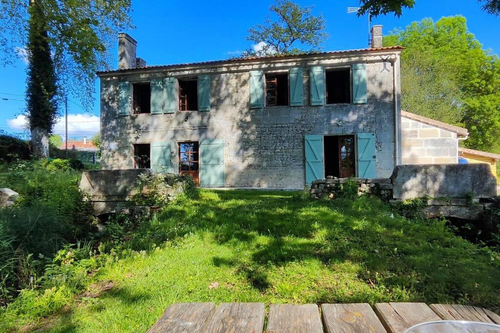 une vieille maison en pierre sur une colline avec une cour dans l'établissement Le Moulin Chardet, à Roullet-Saint-Estèphe