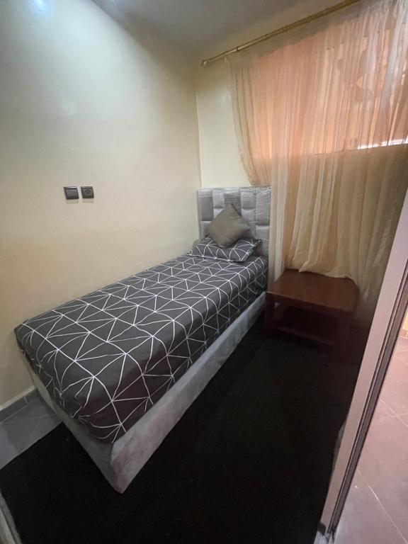 um pequeno quarto com uma cama e uma janela em Cap Juby Apartment 1 em Villa Bens