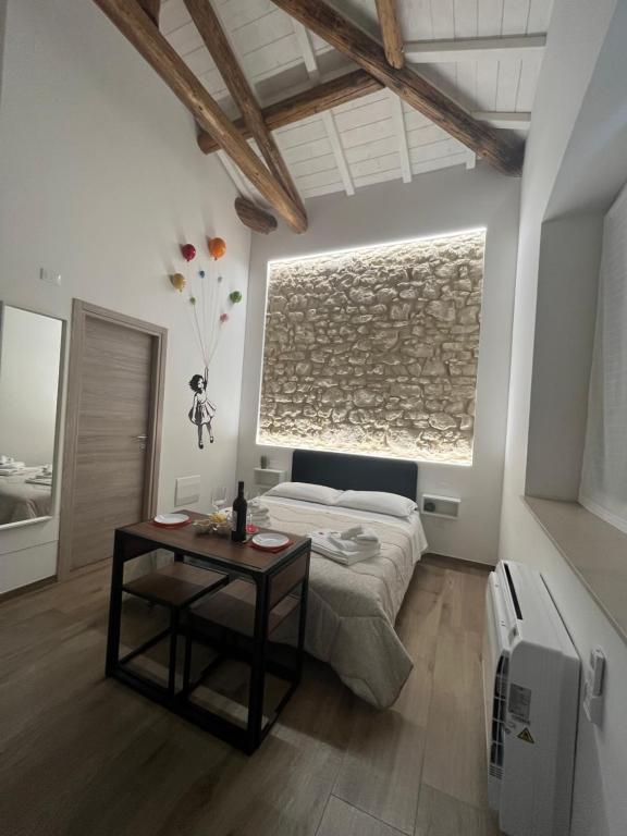 B&B La casa di Ale في فيرونا: غرفة نوم فيها سرير وطاولة فيها