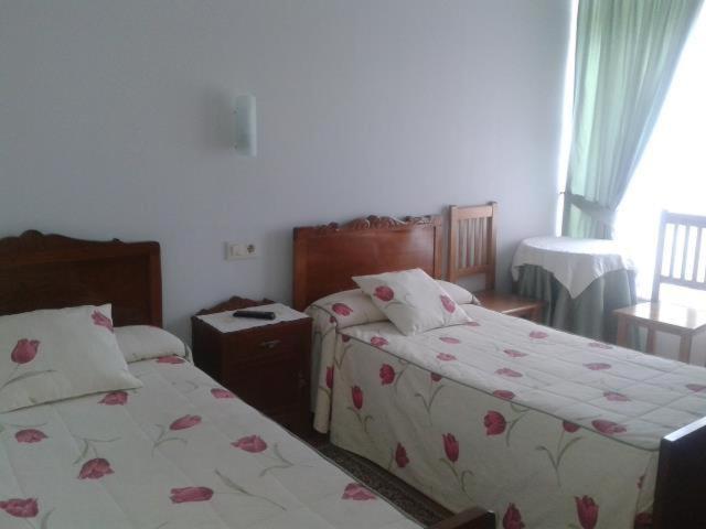 A bed or beds in a room at Hostal Pumar