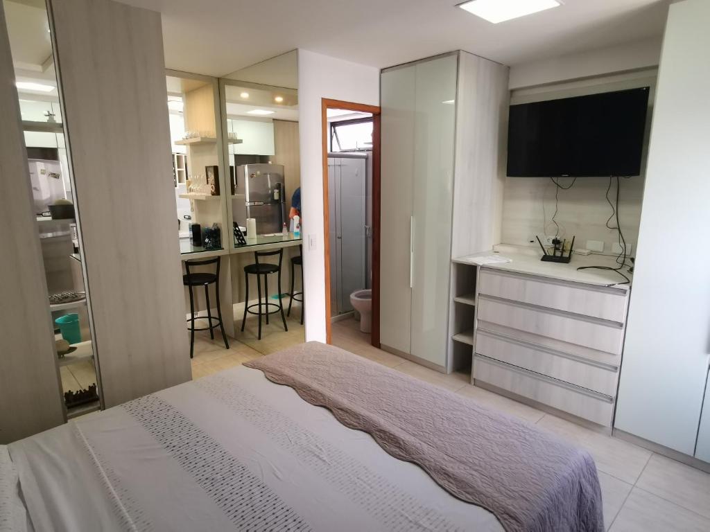 1 dormitorio con 1 cama y cocina con fregadero en Boa Viagem - Charmoso apartamento para casais, en Recife