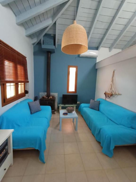 a living room with two blue couches and a table at The House in the Mulberries Trees in Metangítsion