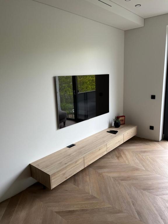 a living room with a tv on a white wall at Taikos apartment 57 in Kaunas