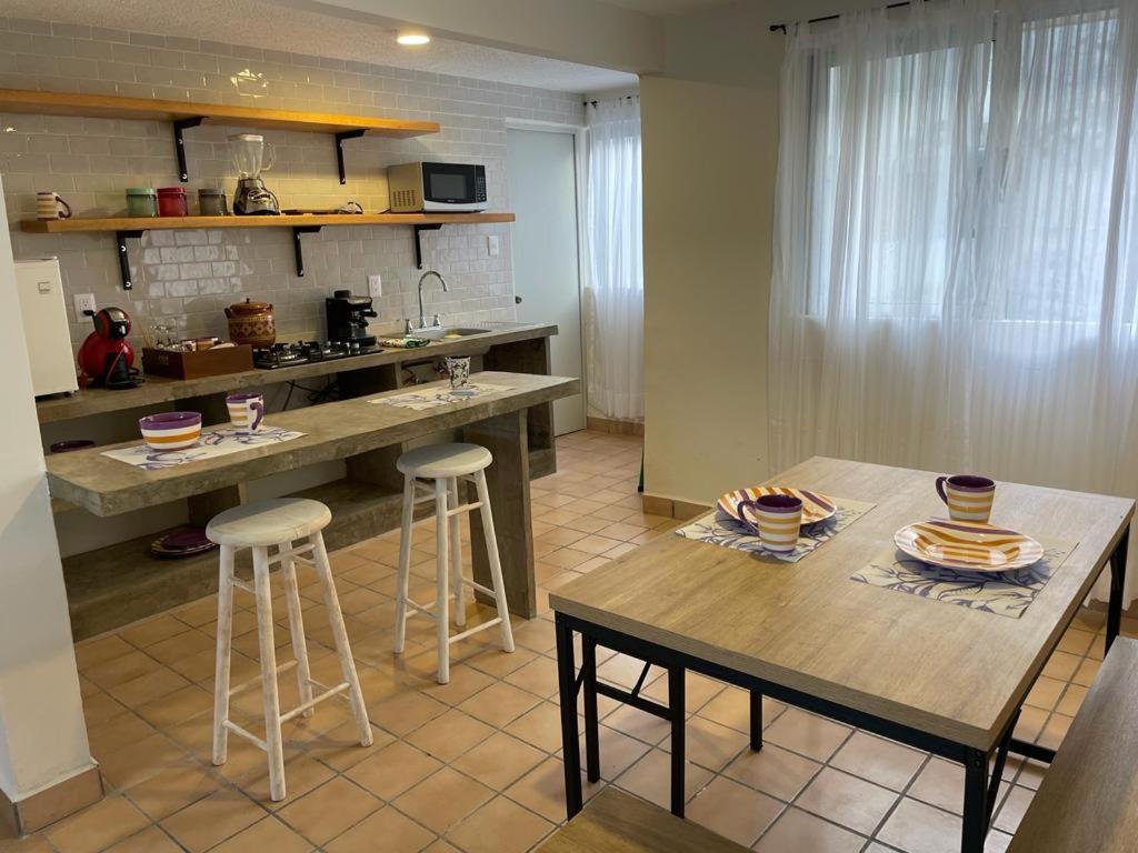 a kitchen with a table and two bar stools at Departamento centro de Boca del Río in Boca del Río
