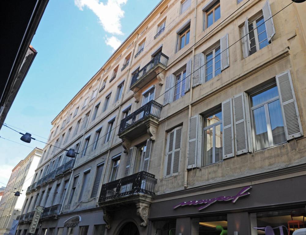 a large building with windows and balconies on a street at LE MONDRIAN - Hôtel de ville - Confort - Paisible - Wi-Fi in Saint-Étienne