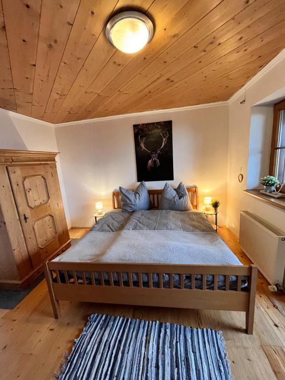 ein Schlafzimmer mit einem großen Bett und einer Holzdecke in der Unterkunft Ferienhaus Praschberg in Niederndorferberg